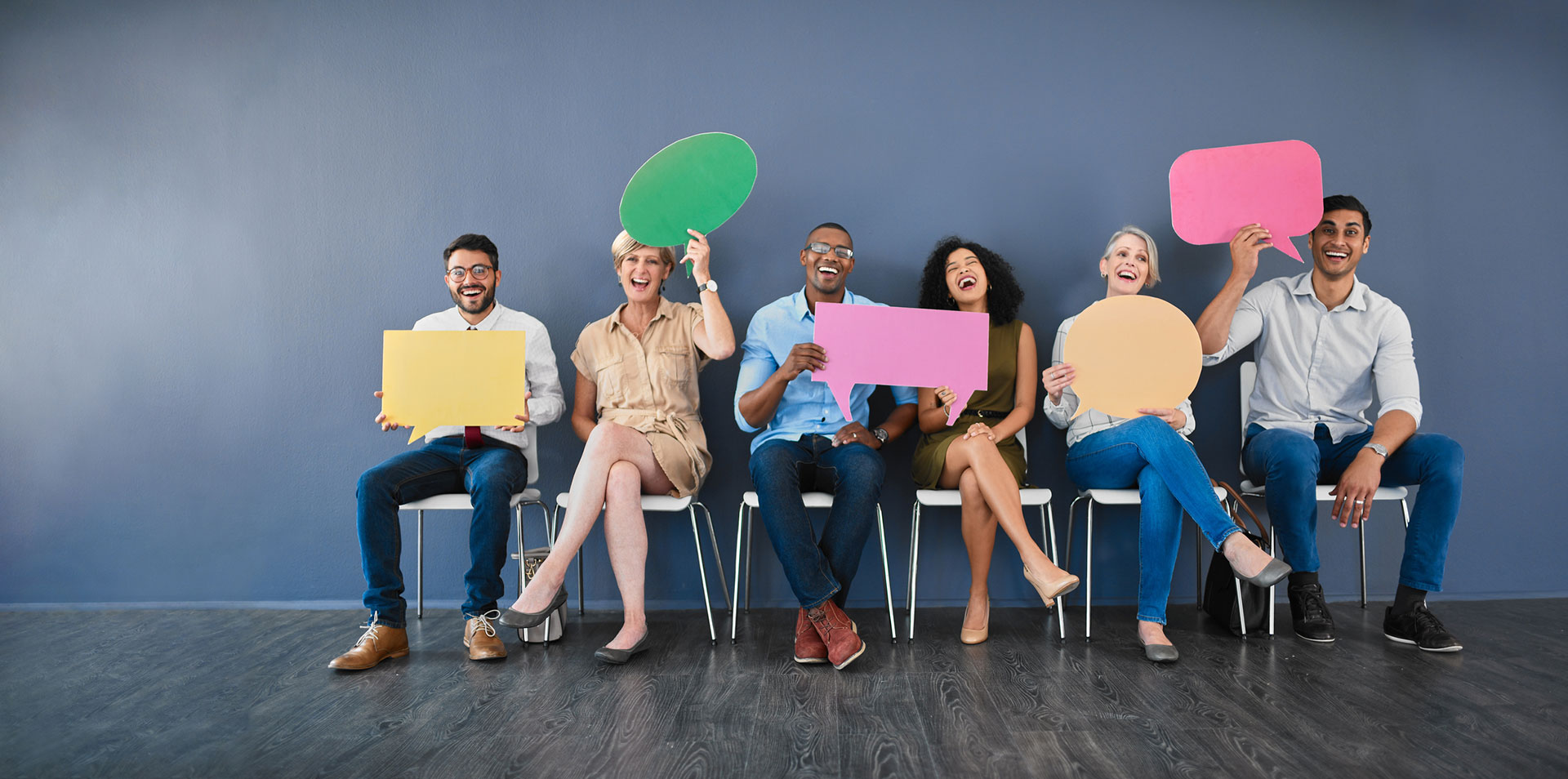 Groupe de personnes levant ensemble une grande clé symbolisant la collaboration et le succès collectif.